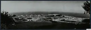 The palace at Vouni seen from the south, with low walls of ruined rooms spreading across a hilltop above the sea.