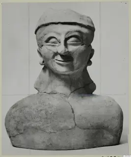 Terracotta bust of a smiling figure in a close-fitting cap, cracked and broken at the neck
