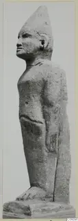 Limestone Cypro-Egyptian standing figure in profile, facing left, with a tall conical headdress