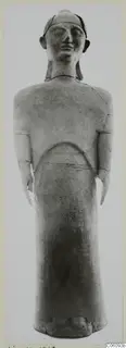 Standing terracotta figure from Ayia Irini, shown frontally against a grey backdrop