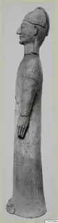 Tall standing terracotta figure in profile facing left, wearing a cap, with one arm bent forward