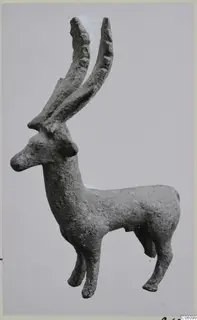 Bronze figurine of a standing animal with two long, ridged horns, shown in side view