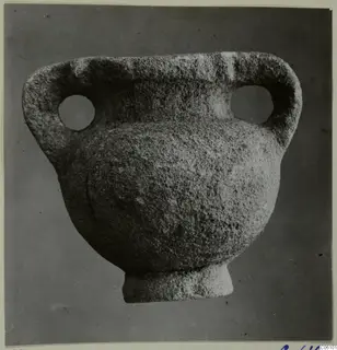 Stone amphora with two loop handles, each pierced by a large round hole, and a short foot