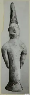 Terracotta figurine of a standing human figure with a tall conical head and arms held at the sides