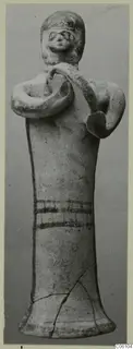 Terracotta figurine from Ayia Irini, arms bent with hands at the chest holding a curved band over one shoulder