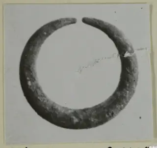 Bronze earring with an open ring and tapering ends, shown as a photograph of a single find.