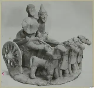 Terracotta figurine of a chariot with two riders, a round shield and a team of harnessed horses, from Ayia Irini