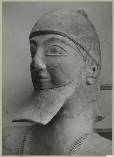 Terracotta statue head and upper body from Ayia Irini, with a close-fitting cap and a long beard with incised lines.