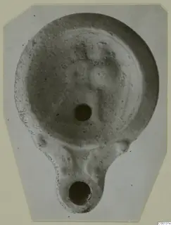 Terracotta oil lamp from Soli, photographed from above, with a filling hole and a nozzle with a wick hole at the lower end.