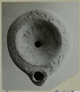 Terracotta oil lamp seen from above, with a band of impressed pattern around the rim.