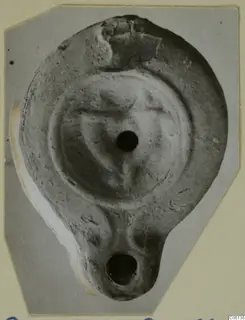 Terracotta oil lamp with a filling hole and a nozzle at the lower end, seen from above.