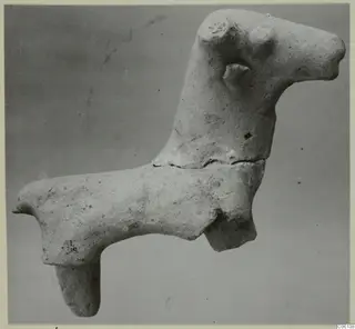 Terracotta figurine of an animal with a long neck and one leg hanging down, from Ayia Irini