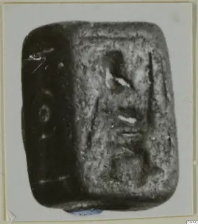 Rectangular stone seal with rounded corners and an engraved face, shown in a photograph on a card mount