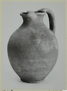 Pottery coarse ware jug with a single handle and a pinched spout.