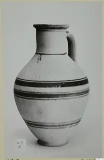 White Painted VI single-handled vessel with dark painted bands, photographed against a plain grey background