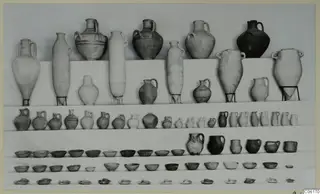 Rows of pottery vessels from Vouni Tomb 1: large jugs and amphorae at the top, with smaller jugs, bowls and saucers in rows below.