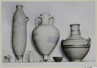 Pottery vessels from Tomb 15 at Vouni, set out in a row against a plain backdrop.