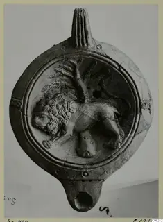 Terracotta lamp with a relief of a lion walking beside a tree or branch on its disc