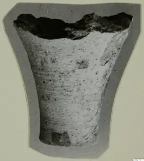 Broken fragment of a vessel, wider at the top, shown on a grey card mount