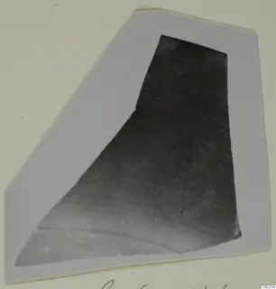 Pottery sherd photographed on a grey card mount, with handwritten caption along the bottom edge