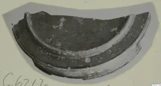 Curved pottery sherd with a raised band running along its outer edge, shown on a grey card mount