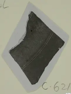 Pottery sherd with fine horizontal grooves and two narrow parallel bands, shown on a pale card mount