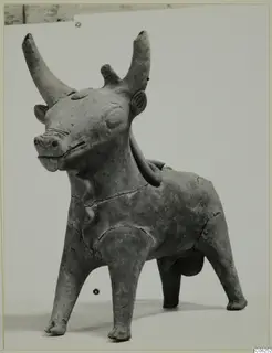 Terracotta figurine of a standing animal with long curved horns and short legs