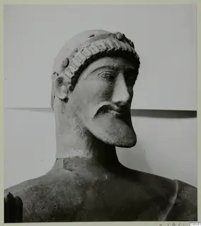 Terracotta sculpture of a bearded male head with a headband, from Mersinaki, photographed in three-quarter view.