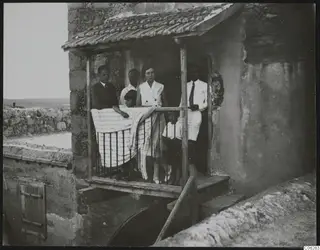 The Gjerstad family on a balcony at Ayia Irini, a striped cloth draped over the railing.