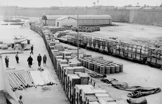 Loaded railway wagons with wooden crates and barrels on the quay at Famagusta