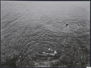 Three people swimming in clear shallow sea water at Kyrenia