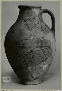 Pottery Plain White VI jug (V.562), reassembled from broken pieces, with a single loop handle and ring base