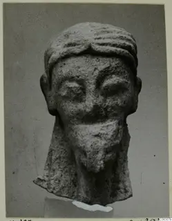 Limestone head of a statue from Kition, front view, with a ridged headband and a square beard