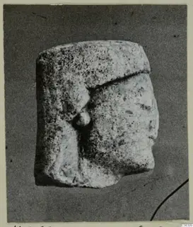 Limestone statuette fragment with a head in profile facing right and a pitted surface