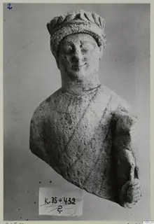 Limestone sculpture of a head and upper body from Kition, wearing a ridged headdress