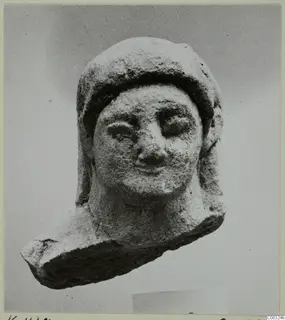 Limestone head statuette from Kition, face turned toward the viewer, with a close-fitting head covering