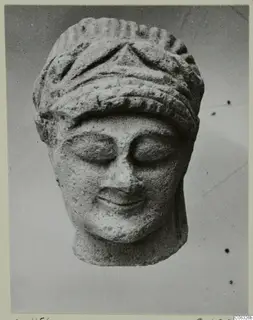Limestone Cypro-Greek I head fragment from Kition, front view, with closed eyes and a ridged headdress.