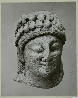 Limestone head fragment from Kition, shown from the front, with a band of rounded knobs across its headdress