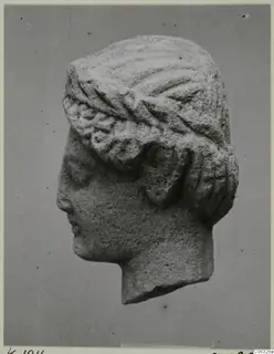 Limestone head sculpture in profile facing left, hair in wavy bands under a broad band, from Kition