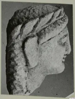 Limestone head from Kition in profile facing right, with a carved headdress and textured hair