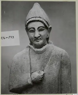 Limestone statue of a head and upper body wearing a tall pointed cap, from Kition