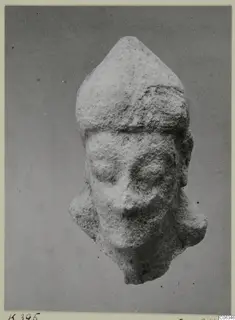 Limestone head fragment with a tall headdress, from Kition