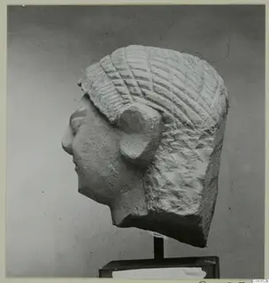 Limestone head statuette in profile facing left, with incised hair, mounted on a dark stand from Kition