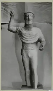 Limestone statue of a standing bearded male figure with one arm raised, from Kition