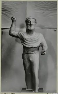 Limestone statue of a bearded standing male figure with one fist raised, from Kition