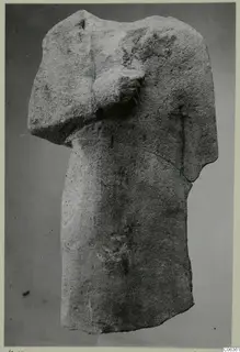 Limestone statue fragment of a headless torso, from Kition, with one arm bent across the chest