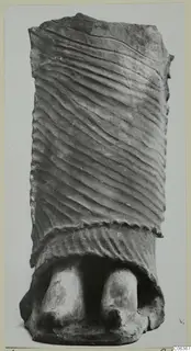 Terracotta object with diagonal grooved surface and two rounded projections at its base