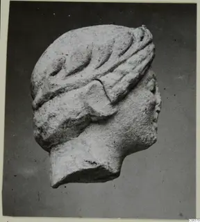 Limestone head fragment from Vouni with a carved leafy band across the top of the head