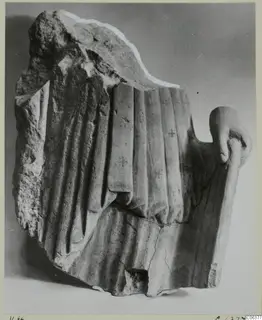 Limestone sculpture fragment from Vouni with carved vertical drapery folds and a hand at the right edge