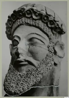 Terracotta head of a bearded male statue wearing a crown of rosettes, shown in close view